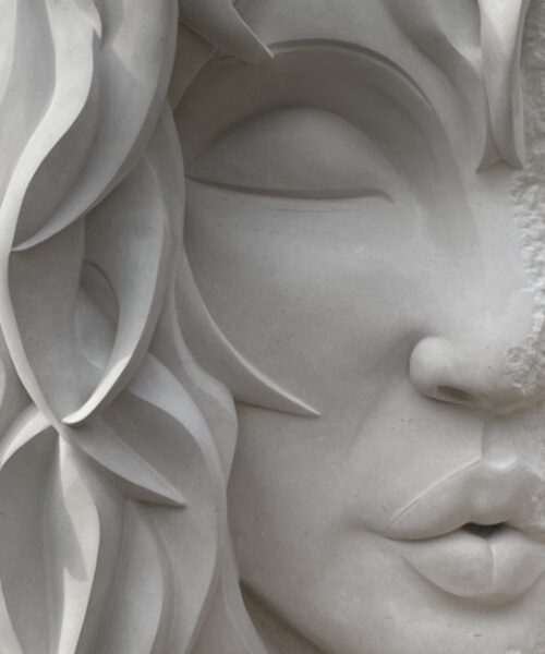 Close-up detail of a hand-carved stone face