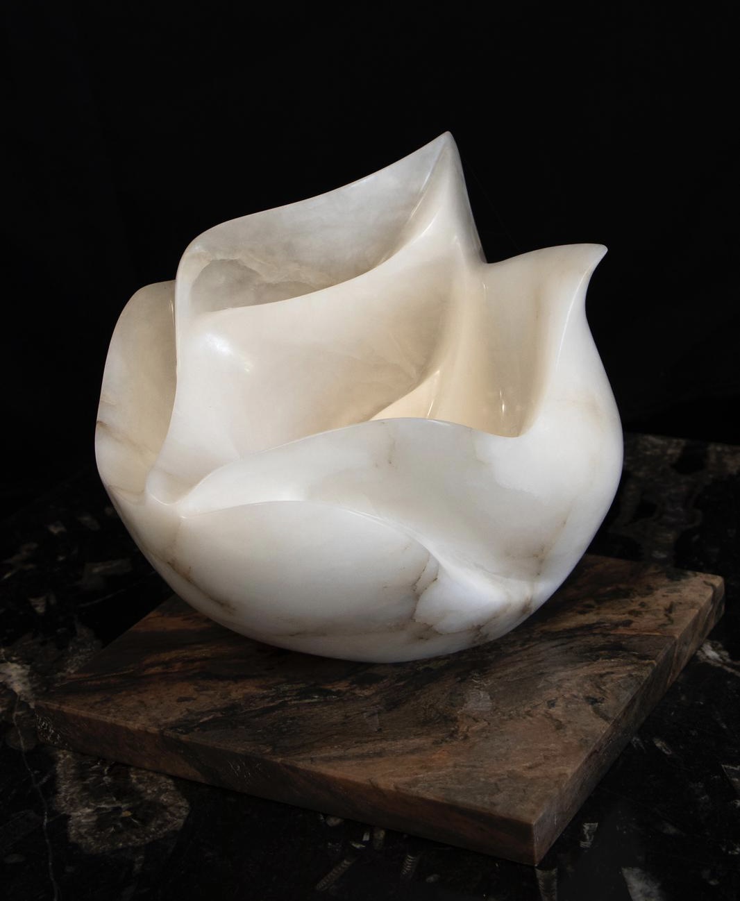 Commissions – alabaster sculpture Pale alabaster sculpture against a dark background