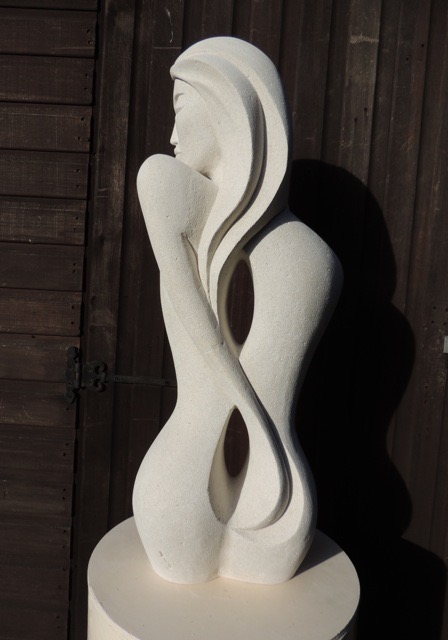 Pale figurative stone sculpture with flowing interlocking forms